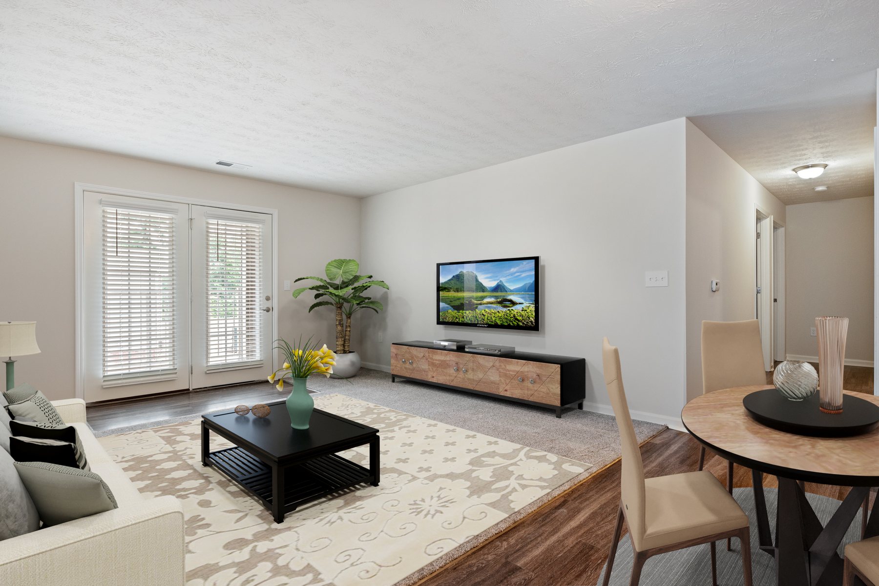Open living room and dining area in a Cane Run Station two-bedroom home, with wood-look floors and sliding doors to a private patio